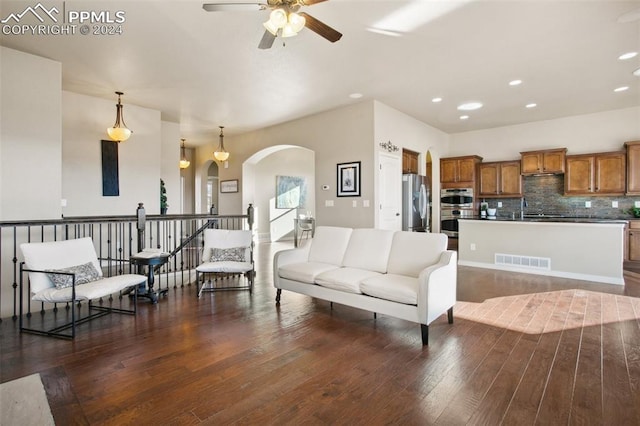 living room featuring dark hardwood / wood-style floors, ceiling fan, and sink