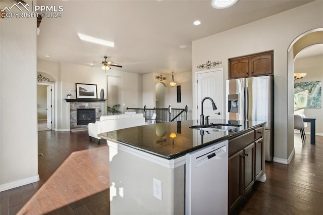 kitchen with dark wood-type flooring, white dishwasher, a center island with sink, and sink