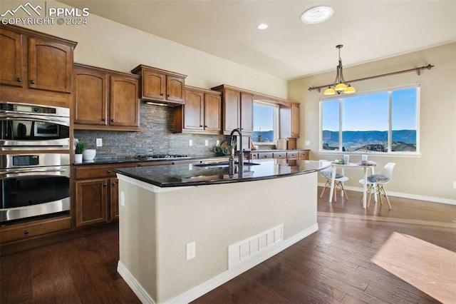 kitchen featuring sink, dark wood-type flooring, a mountain view, decorative light fixtures, and appliances with stainless steel finishes