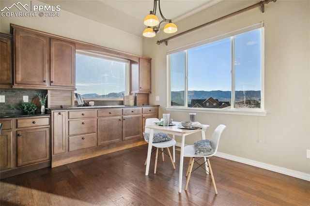 dining space featuring a mountain view, dark wood-type flooring, and an inviting chandelier