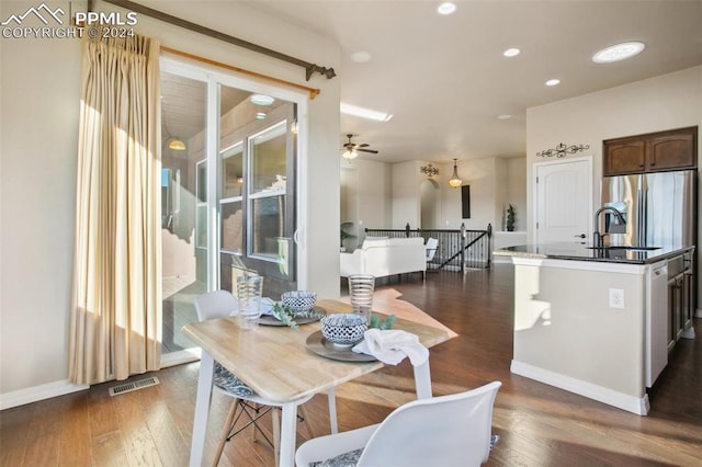 dining space featuring ceiling fan and dark wood-type flooring