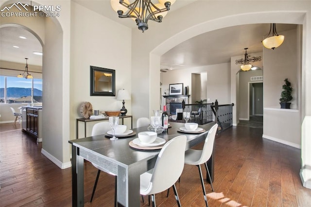 dining space with dark hardwood / wood-style floors, a mountain view, and an inviting chandelier