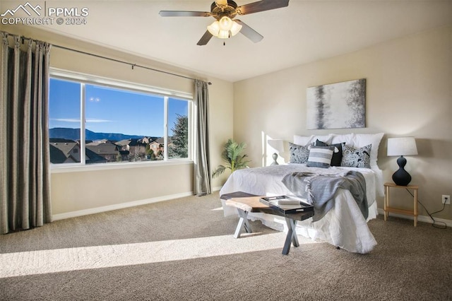 bedroom with carpet flooring, a mountain view, and ceiling fan