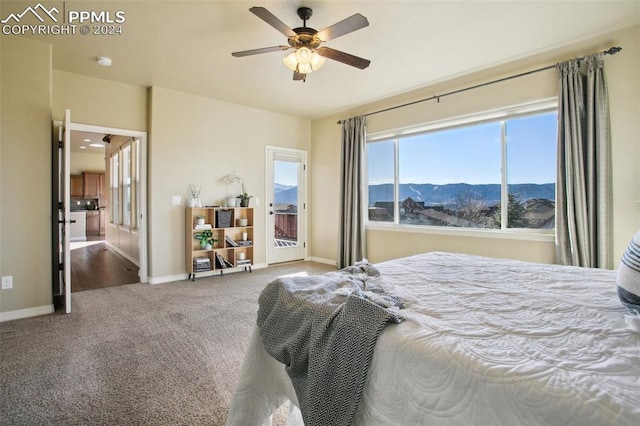 carpeted bedroom featuring a mountain view and ceiling fan