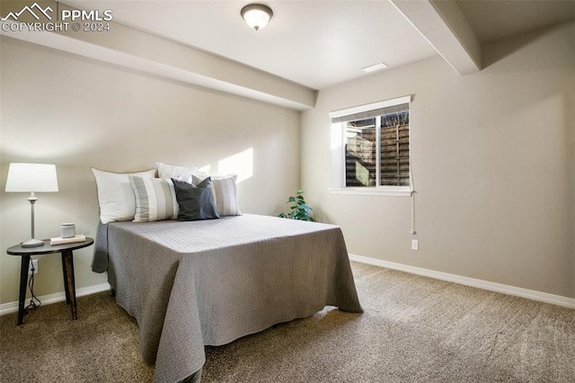 carpeted bedroom featuring beamed ceiling