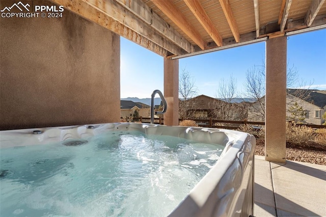 view of patio featuring a mountain view and a hot tub