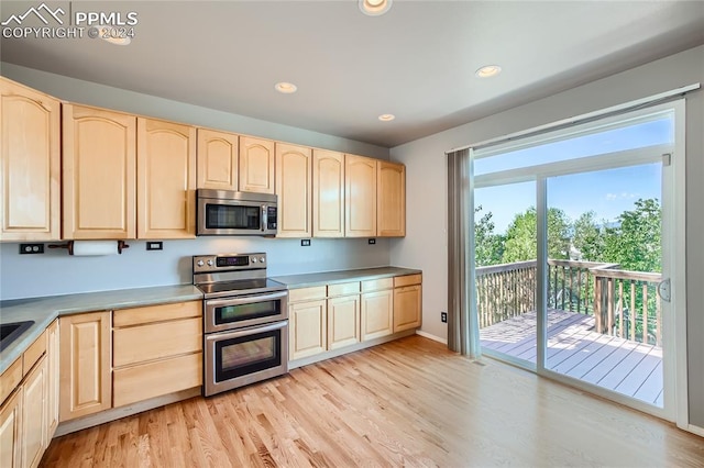 kitchen featuring light brown cabinets, stainless steel appliances, and light hardwood / wood-style flooring