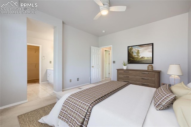 bedroom featuring a walk in closet, a closet, ceiling fan, and light colored carpet