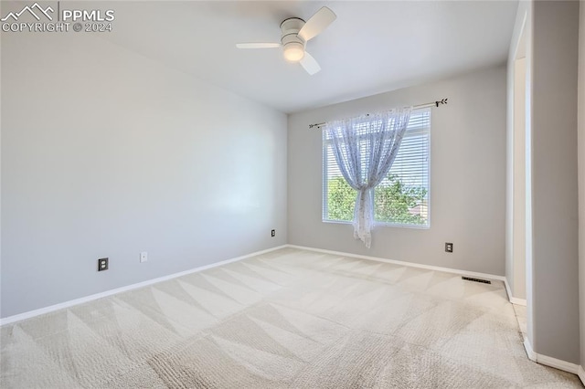 carpeted spare room featuring ceiling fan