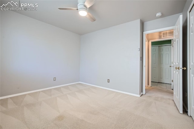 unfurnished bedroom with ceiling fan and light carpet