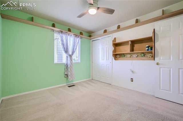 carpeted spare room featuring ceiling fan