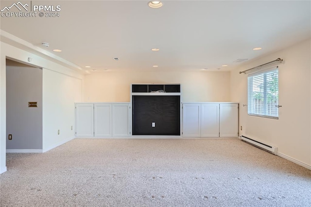 carpeted spare room featuring baseboard heating