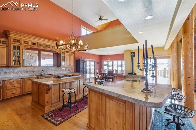 kitchen featuring a kitchen breakfast bar, light hardwood / wood-style flooring, a kitchen island with sink, and a healthy amount of sunlight