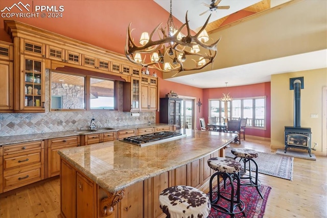 kitchen featuring backsplash, a wood stove, and light hardwood / wood-style floors