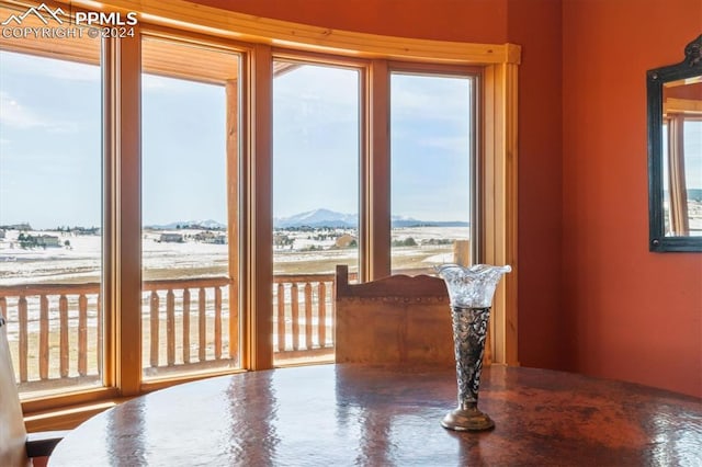 dining space with a mountain view, a healthy amount of sunlight, and concrete flooring