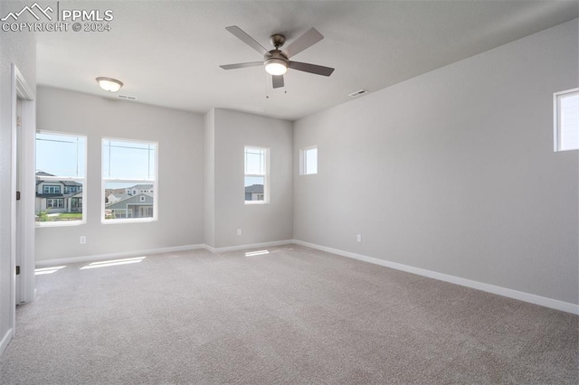 carpeted empty room with plenty of natural light and ceiling fan