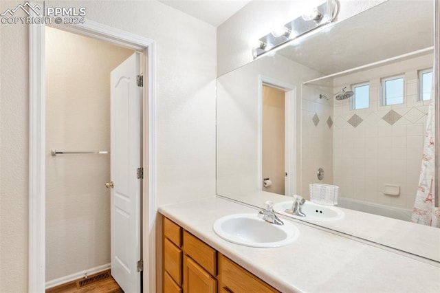 bathroom with hardwood / wood-style floors, vanity, and shower / tub combo with curtain