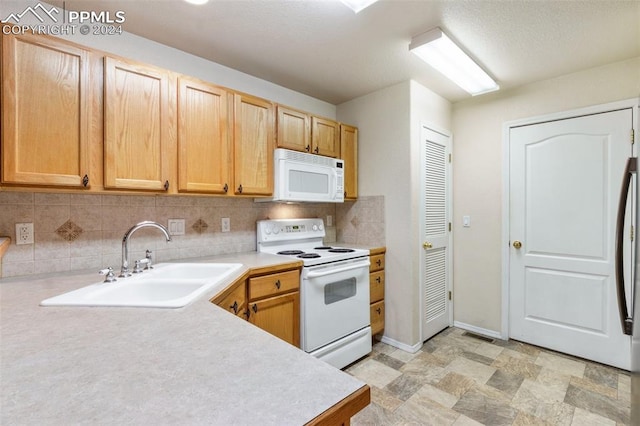 kitchen featuring tasteful backsplash, sink, and white appliances