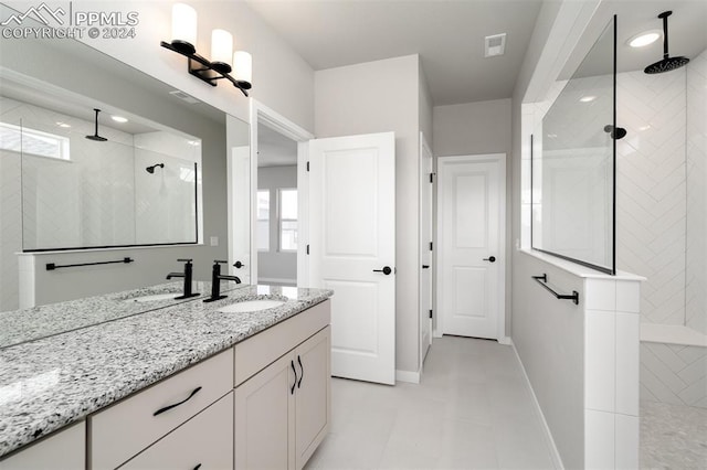 bathroom featuring tiled shower and vanity