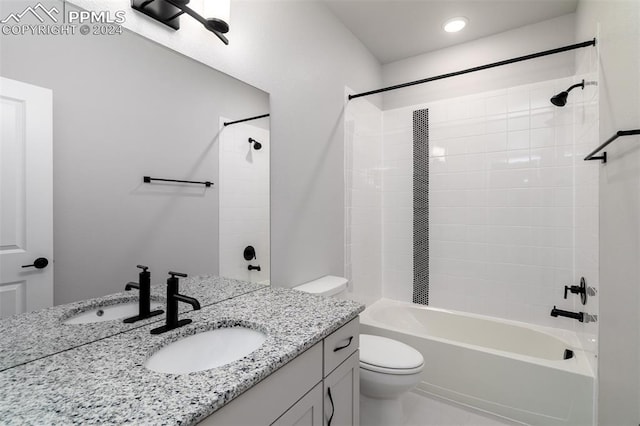 full bathroom with tiled shower / bath, vanity, and toilet