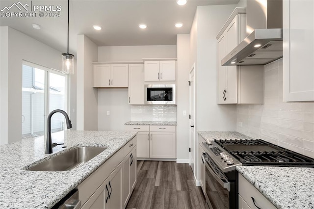 kitchen featuring white cabinets, pendant lighting, wall chimney range hood, and stainless steel range with gas stovetop