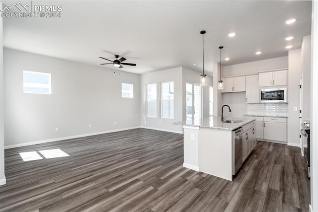 kitchen featuring stainless steel appliances, sink, a center island with sink, white cabinetry, and hanging light fixtures