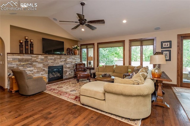 living room with dark hardwood / wood-style flooring, ceiling fan, a fireplace, and lofted ceiling