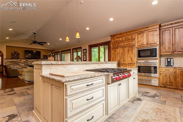 kitchen with ceiling fan, a center island, stainless steel appliances, backsplash, and decorative light fixtures