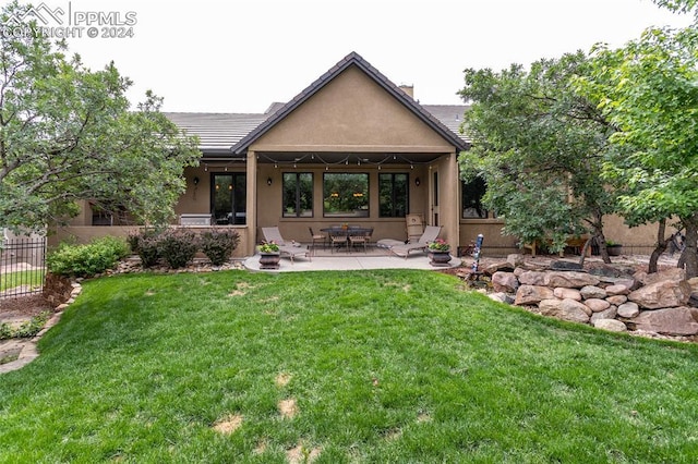 back of property featuring a lawn and a patio area