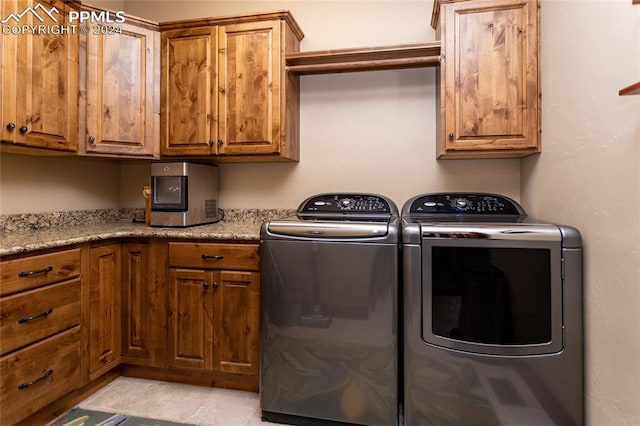 washroom with cabinets and washing machine and dryer