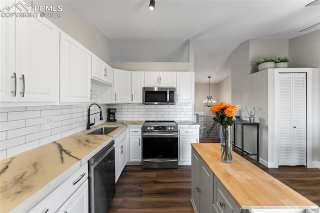 kitchen with sink, white cabinets, pendant lighting, and appliances with stainless steel finishes