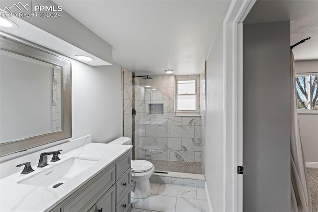 bathroom featuring vanity, toilet, and tiled shower