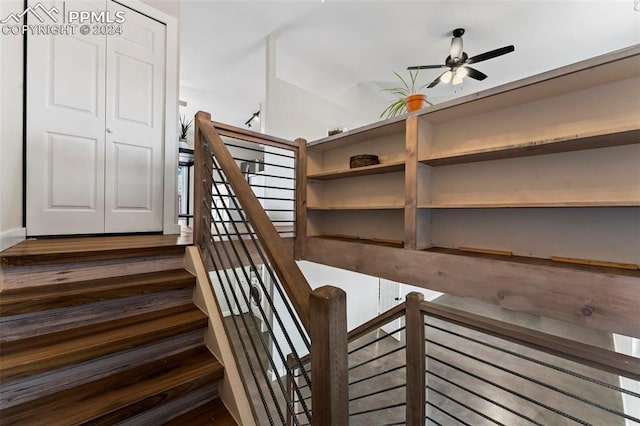 stairs featuring ceiling fan