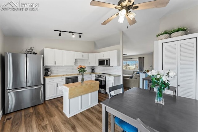 kitchen with white cabinetry, tasteful backsplash, dark hardwood / wood-style floors, lofted ceiling, and appliances with stainless steel finishes