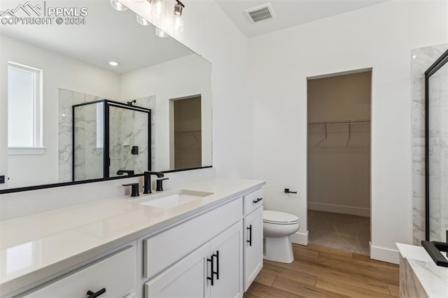 bathroom featuring vanity, hardwood / wood-style flooring, toilet, and walk in shower