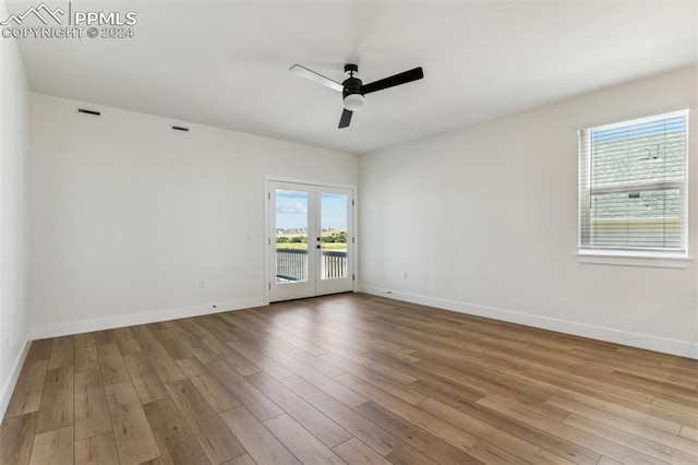 unfurnished room with ceiling fan, light hardwood / wood-style flooring, and french doors