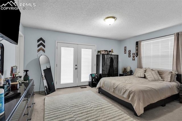 carpeted bedroom featuring access to outside, french doors, and a textured ceiling