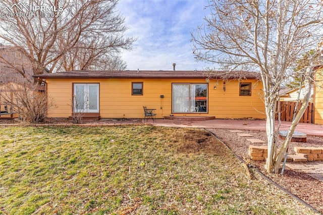 rear view of house featuring a patio area and a lawn