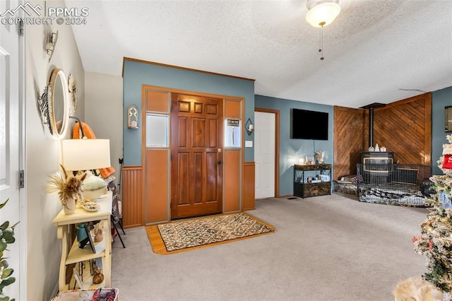 foyer entrance featuring a textured ceiling and light carpet