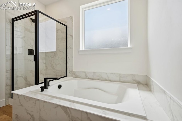 bathroom featuring separate shower and tub