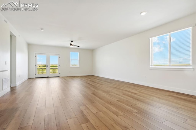 spare room with ceiling fan, light wood-type flooring, and french doors