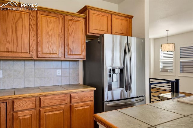 kitchen featuring backsplash, stainless steel fridge, and tile counters