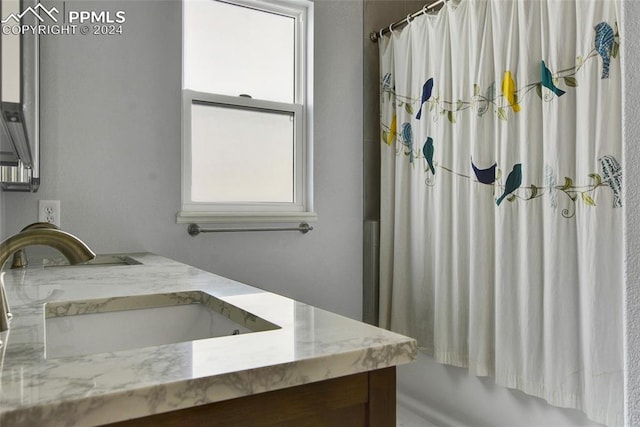 bathroom featuring shower / bath combination with curtain, a healthy amount of sunlight, and vanity