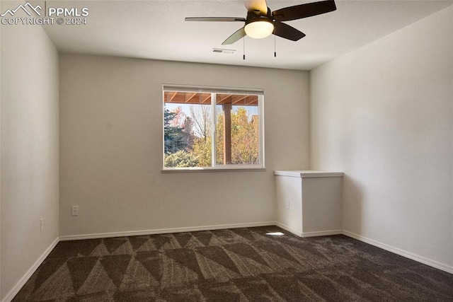 unfurnished room featuring ceiling fan and dark colored carpet