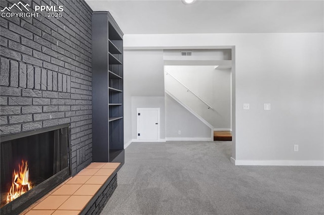 unfurnished living room featuring built in shelves, a brick fireplace, and carpet