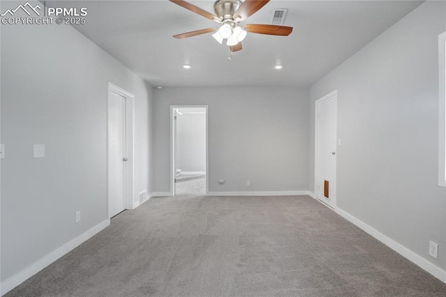 spare room featuring light colored carpet and ceiling fan