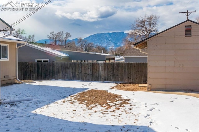 yard layered in snow with a mountain view