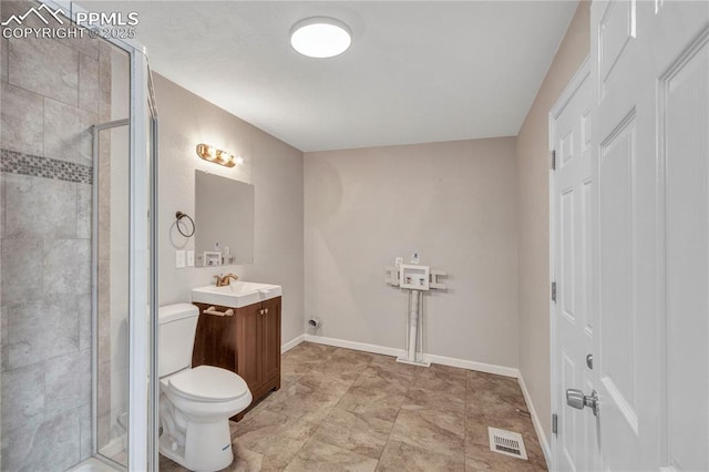 bathroom with vanity, a shower with shower door, and toilet