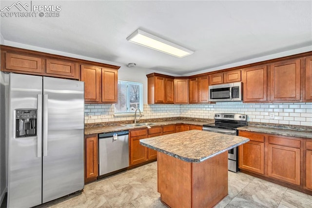 kitchen featuring appliances with stainless steel finishes, a center island, decorative backsplash, and sink