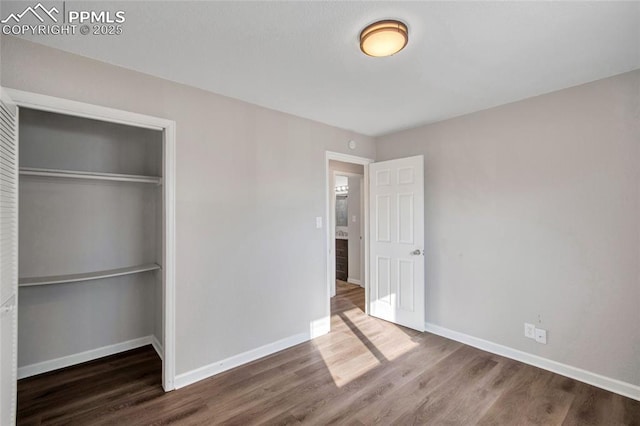 unfurnished bedroom featuring dark wood-type flooring and a closet